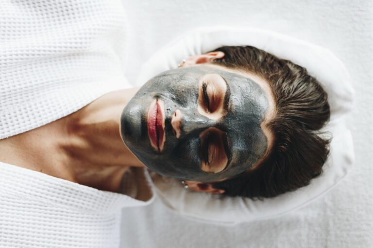 Woman relaxing with a dark carbon mask on her face during a carbon laser facial.